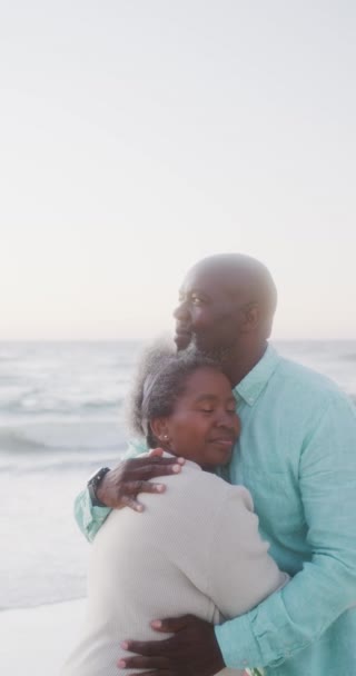 非洲裔美国老人夫妇在海滩拥抱的垂直录像 动作缓慢 花费高质量的时间 生活方式 退休和度假概念 — 图库视频影像