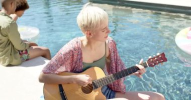 Yazın havuz partisinde gitar çalan mutlu arkadaş grubu. Ev kavramında arkadaşlık ve kaliteli zaman geçirme.
