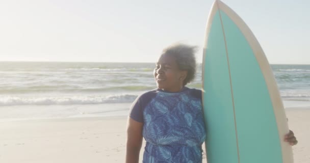 Feliz Mujer Afroamericana Mayor Sosteniendo Tabla Surf Playa Cámara Lenta — Vídeos de Stock