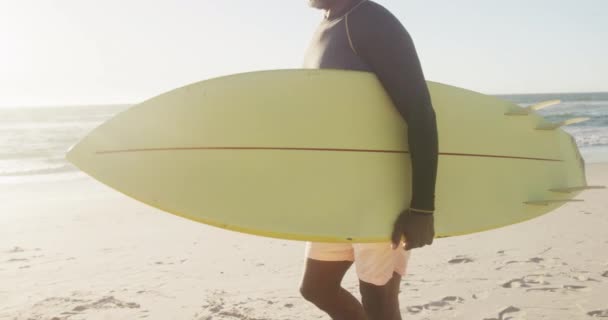 Feliz Hombre Afroamericano Mayor Caminando Sosteniendo Tabla Surf Playa Cámara — Vídeos de Stock