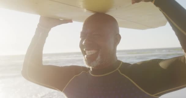 Glad Senioramerikan Som Går Och Håller Surfingbrädan Stranden Slow Motion — Stockvideo