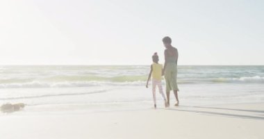 Mutlu Afro-Amerikan anne ve kızı sahile iniyor, yavaş çekimde, fotokopi aletiyle. Kaliteli zaman, yaşam tarzı, aile ve tatil konsepti.