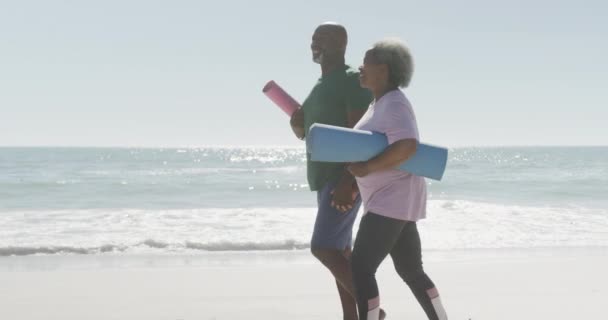 Szczęśliwa Starsza Afrykańska Para Chodząca Trzymająca Maty Jogi Plaży Zwolnionym — Wideo stockowe