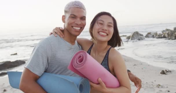 一对快乐的小鸟夫妇在海滩拿着瑜伽垫的画像 动作缓慢 健康的生活方式 浪漫和度假的概念 — 图库视频影像