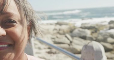 Deniz kenarında gezinen mutlu kıdemli Afrikalı Amerikalı kadın portresi. Kopya alanı, ağır çekim. Kaliteli zaman, yaşam tarzı, tatil ve emeklilik.