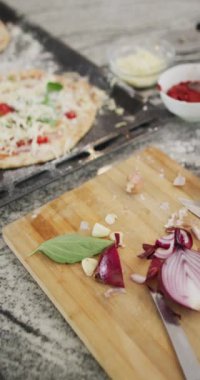 Mutfakta kırmızı soğan ve pizzanın dikey videosu, yavaş çekim. Yiyecek, malzeme ve beslenme konsepti.