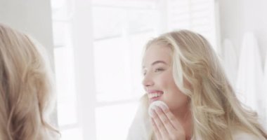 Kafkasyalı mutlu kadın portresi aynanın önünde ağır çekimde makyaj yapıyor. Yaşam tarzı, evde kaliteli zaman geçirme ve vücut kapsamı.