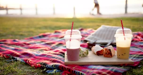 海の遊歩道のピクニックでスムージーとトルティーヤで毛布の閉鎖 スローモーション 質の高い時間 ライフスタイル 夏と休暇を過ごす — ストック動画