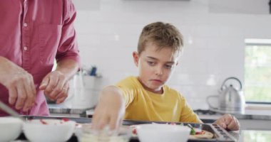 Kafkas dedem ve torunum mutfakta pizza yapıyor, ağır çekimde. Kaliteli zaman geçirme, aile hayatı, aile ve çocukluk.