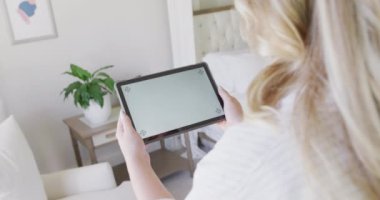 Kafkasyalı kadın ağır çekimde fotokopi alanı olan tablet kullanıyor. Yaşam tarzı, evde kaliteli zaman geçirme ve vücut kapsamı.