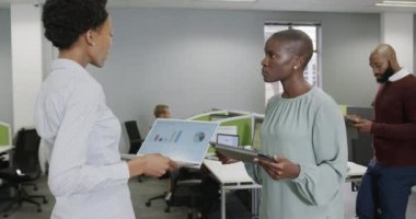 Çeşitli iş adamları işi tartışıyor ve ofiste teknolojiyi yavaş çekimde kullanıyorlar. İş, takım çalışması, kapsayıcılık ve iletişim.