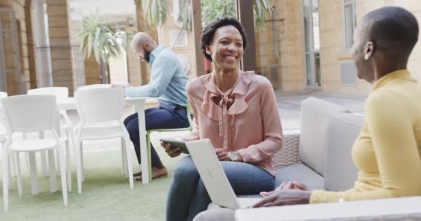 Две Счастливые Африканские Деловые Женщины Разговаривают Смеются Используют Ноутбук Открытом — стоковое видео
