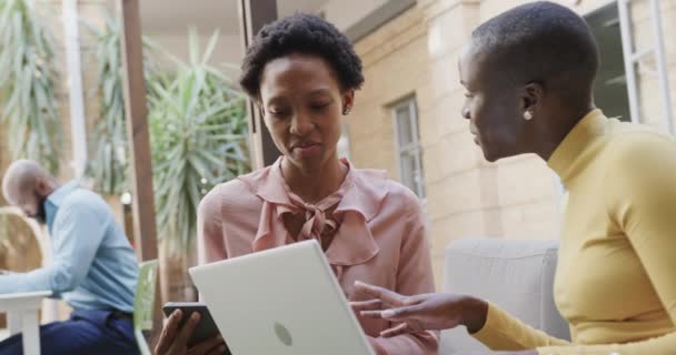 Две Счастливые Африканские Деловые Женщины Разговаривают Смеются Используют Ноутбук Открытом — стоковое видео