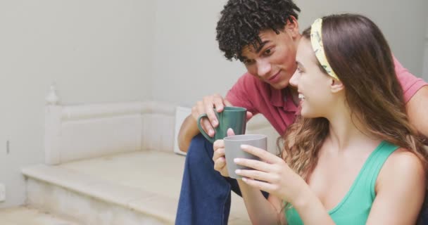 Szczęśliwa Para Mieszańców Spędza Czas Domu Pijąc Kawę Siedząc Schodach — Wideo stockowe