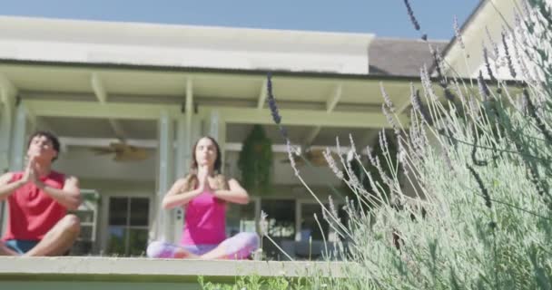 Coppia Biraciale Concentrata Che Pratica Yoga Medita Giardino Nella Giornata — Video Stock