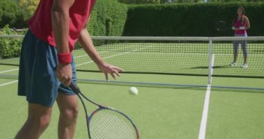 Güneşli bir günde bahçede tenis oynayan mutlu çift. Boş zaman, sağlık ve etkinlik.