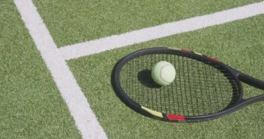 Tenis raketini ve topunu güneşli bir günde tenis kortunda kapat. Spor, sağlık ve etkinlik.