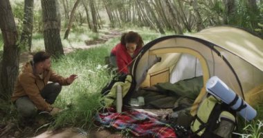 Mutlu Afro-Amerikan çifti ormanda çadır kuruyor, ağır çekimde. Kaliteli zaman geçirmek, yaşam tarzı, doğa, yürüyüş ve kamp..