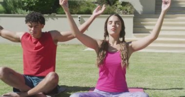 Yoga yapan ve güneşli bir günde bahçede meditasyon yapan çift odaklı. Boş zaman, sağlık ve etkinlik.