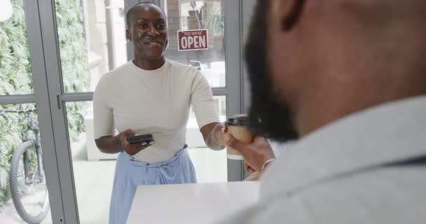 Uśmiechnięta Afroamerykanka Płacąca Kawę Wynos Kawiarni Smartfonem Zwolnionym Tempie Lokalny — Wideo stockowe