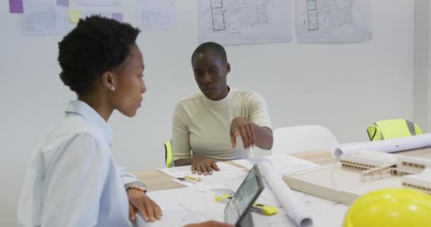 Две Африканские Американские Женщины Архитекторы Чертежами Обсуждении Использовании Планшета Офисе — стоковое видео