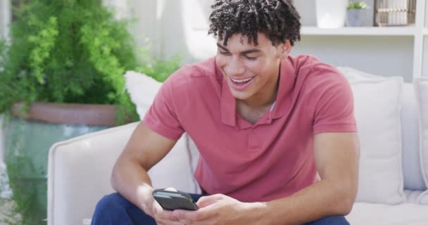 Gelukkig Biracial Man Tijd Doorbrengen Thuis Met Behulp Van Smartphone — Stockvideo