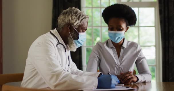 Αφροαμερικάνος Ανώτερος Άντρας Γιατρός Στο Σπίτι Επισκέπτεται Γυναίκα Ασθενή Φορώντας — Αρχείο Βίντεο