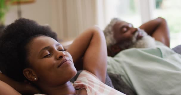 一对快乐的非洲裔美国夫妇躺在沙发上 转过身对着彼此微笑 隔离检疫期间单独呆在家里 — 图库视频影像