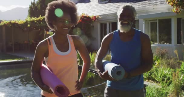 Afro Amerikaans Seniorenpaar Traint Buiten Yoga Matten Dragend Zonnige Tuin — Stockvideo
