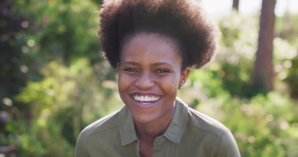 日当たりの良い庭に立つアフリカ系アメリカ人女性の笑顔の肖像画 隔離されたまま家にいると — ストック動画