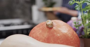 Sebzeleri ve otları kapatın ve mutfakta beyaz bir kadın pişirin, ağır çekimde. Kıdemli yaşam tarzı, yemek pişirme ve sağlıklı beslenme, değişmemiş model.
