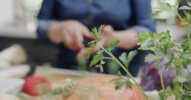 Mutfakta otları kesen yaşlı beyaz bir kadının orta kesimi, ağır çekim. Yaşlı yaşam tarzı, beslenme ve sağlıklı beslenme, değişmemiş model..