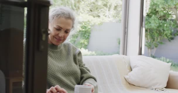 Ευτυχισμένος Ανώτερος Καυκάσιος Γυναίκα Κάθεται Στον Καναπέ Πίνοντας Τσάι Και — Αρχείο Βίντεο