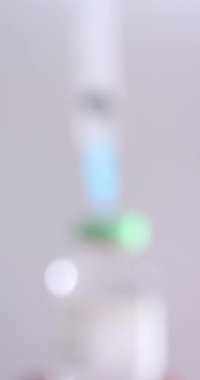 Gri arka planda insülin tüpü ve şırınganın dikey videosu, yavaş çekim. Kan şekeri, Diyabet ve Sağlık Bilinci.