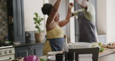 Happy senior african american couple dancing in kitchen in slow motion. Spending quality time at home, retirement and food.