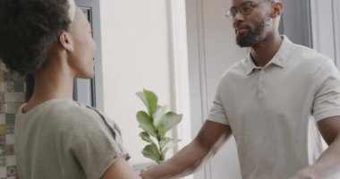 Mutlu Afro-Amerikan çifti ağır çekimde ktichen 'de el ele tutuşup dans ediyor. Evde kaliteli zaman geçirmek, neşe ve aşk.