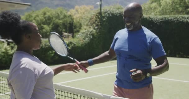 Szczęśliwa Afrykańska Para Seniorów Grająca Tenisa Przytulająca Się Korcie Tenisowym — Wideo stockowe