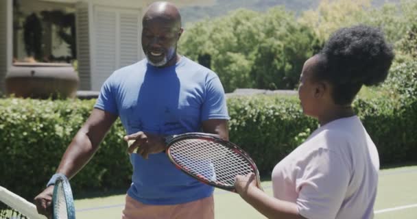 테니스 라켓을 테니스 코트에서 동작으로 말하는 아프리카 미국인 커플을 합니다 — 비디오