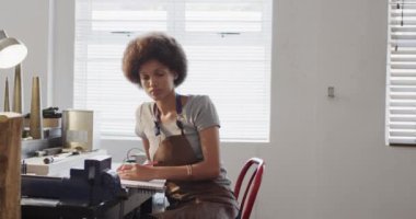 Ağır çekimde atölyede mücevher tasarımı yapan melez bir kadın işçi. Mücevher, zanaat ve küçük işletmeler..