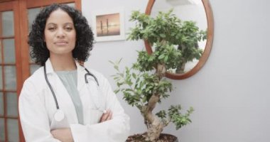 Laboratuvar önlüğü, steteskop, fotokopi alanı ve ağır çekim giyen çift ırklı kadın doktor portresi. Sağlık personeli, ilaç ve sağlık hizmetleri.