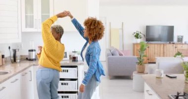 Mutfakta yavaş çekimde dans eden mutlu lezbiyen çift. Kaliteli zaman geçirmek, neşe, eğlence ve aşk.