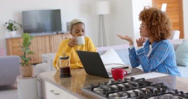 Yavaş çekimde konuşan ve dizüstü bilgisayar kullanan mutlu lezbiyen çift. Kaliteli zaman, eğlence, teknoloji ve aşk harcamak.