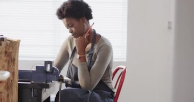 Afrikalı Amerikalı kadın işçi stüdyoda yavaş çekimde mücevher tasarımı yapmakla meşgul. Mücevher, zanaat ve küçük işletmeler..