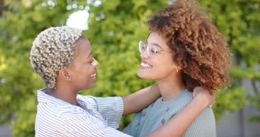 Bahçede yavaşça kucaklaşan mutlu lezbiyen kadın çiftin portresi. Kaliteli zaman geçirmek, neşe ve aşk.