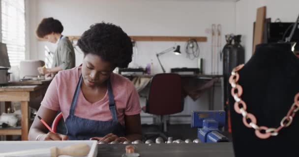 スローモーションでジュエリースタジオでジュエリーのデザインを描く忙しいアフリカ系アメリカ人女性労働者 ジュエリー 工芸品 中小企業 — ストック動画