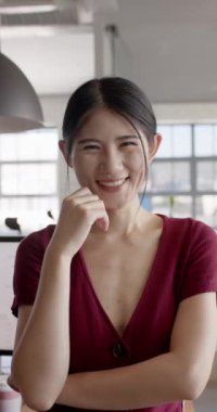 Ofiste gülümseyen Asyalı iş kadını portresinin dikey videosu. İş, iş ve güven.