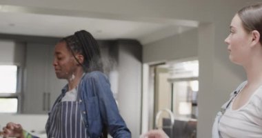 Mutfakta un ile yavaş çekimde oynayan çeşitli genç bayan arkadaşlar. Arkadaşlık, hafta sonu, yemek pişirme ve yaşam tarzı..