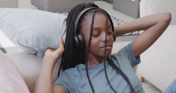 アフリカ系アメリカ人の10代の少女がヘッドフォンをして音楽を聴いている テクノロジー リラクゼーション ライフスタイル — ストック動画