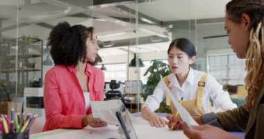 Masadaki çeşitli iş yaratıcıları günlük ofis toplantılarında ağır çekimde iş tartışıyorlar. Günlük ofis, iş, takım çalışması ve yaratıcı çalışma.