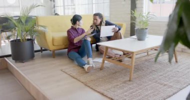 Tablet kullanan ve ofiste ağır çekimde iş tartışan mutlu iş adamları. İş, teknoloji ve takım çalışması.